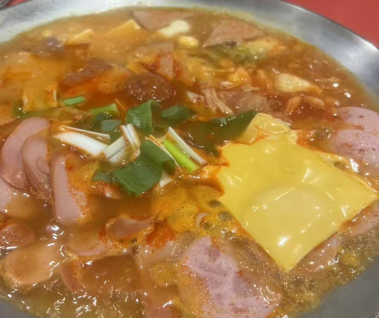 Healthy Korean Budaejjigae and Texas Brisket Kimchi Stew fusion dish served with side dishes