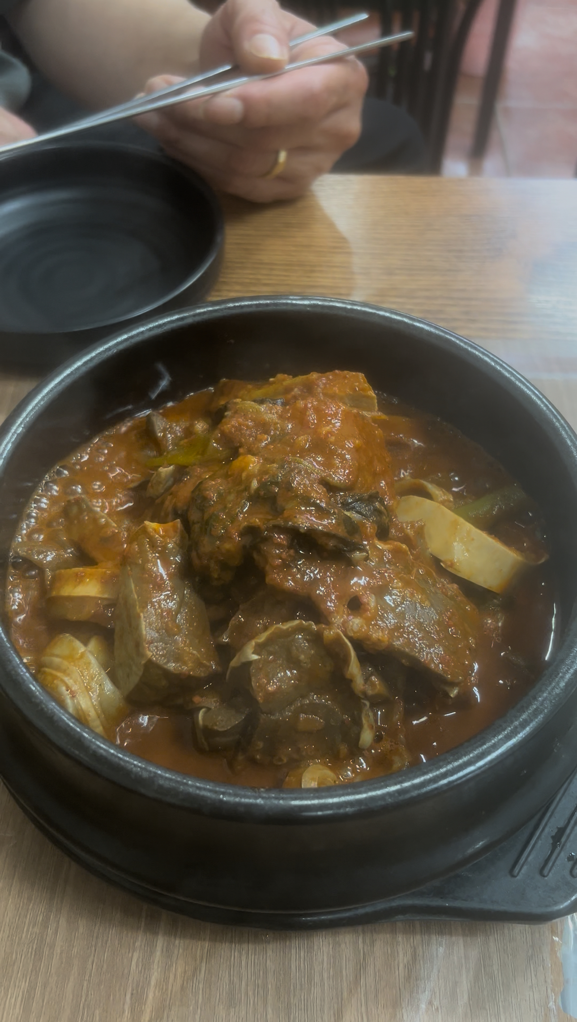 Spicy stir-fried beef lung sizzling in a hot stone pot.